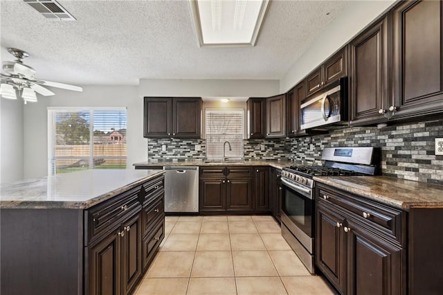 kitchen with visible vents, a ceiling fan, a sink, stainless steel appliances, and light tile patterned flooring