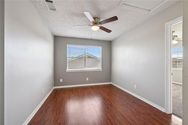 unfurnished room featuring hardwood / wood-style floors, plenty of natural light, visible vents, and a textured ceiling