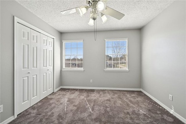 unfurnished bedroom featuring a closet, baseboards, carpet floors, and a textured ceiling