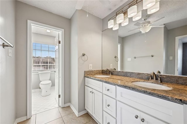 bathroom with tile patterned flooring, double vanity, ceiling fan, and a sink