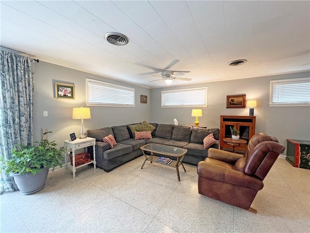 living room featuring plenty of natural light, a ceiling fan, and visible vents