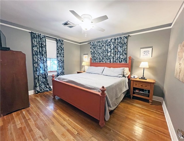 bedroom featuring crown molding, baseboards, and hardwood / wood-style flooring