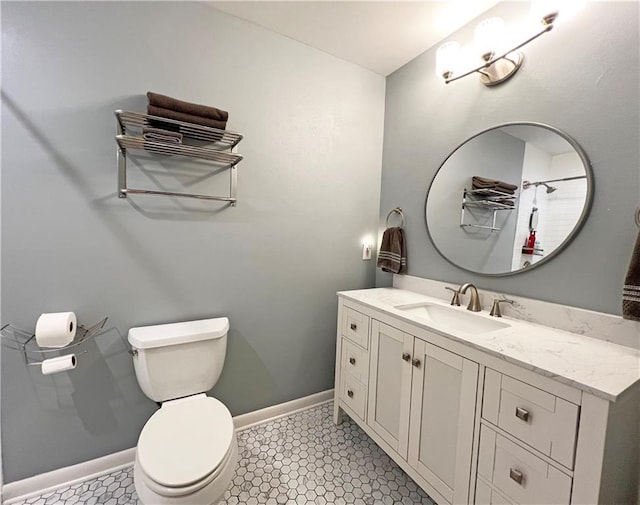 bathroom featuring vanity, toilet, and baseboards