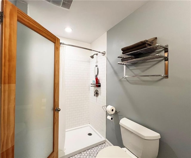 bathroom with visible vents, a stall shower, and toilet