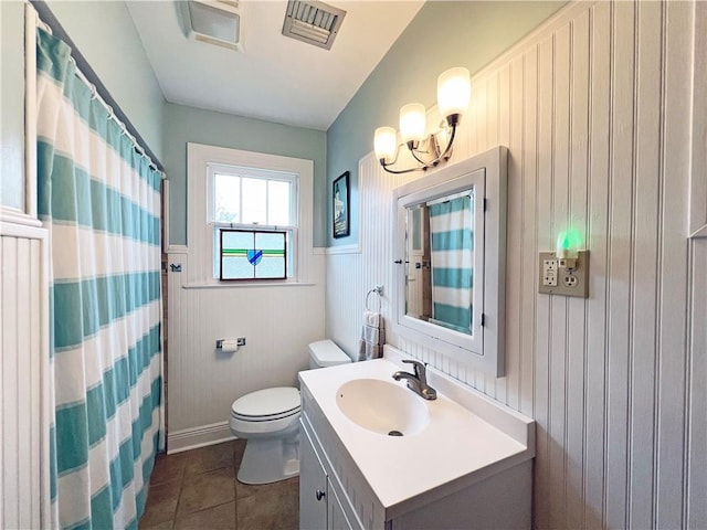 bathroom featuring visible vents, toilet, wainscoting, tile patterned flooring, and vanity