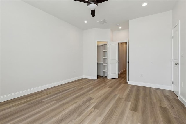 unfurnished bedroom with visible vents, a walk in closet, baseboards, recessed lighting, and light wood-style flooring