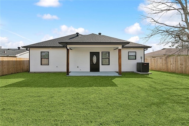 rear view of property featuring central air condition unit, a lawn, a patio, and a fenced backyard