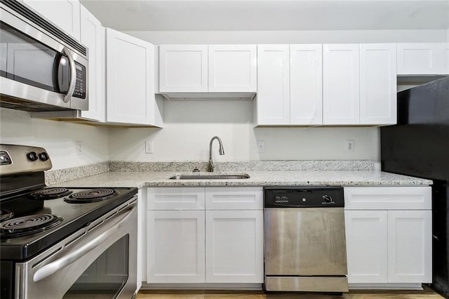 3000 July St Unit 2115, Baton Rouge, LA 70808 - kitchen featuring a sink, light stone counters, appliances with stainless steel finishes, and white cabinets