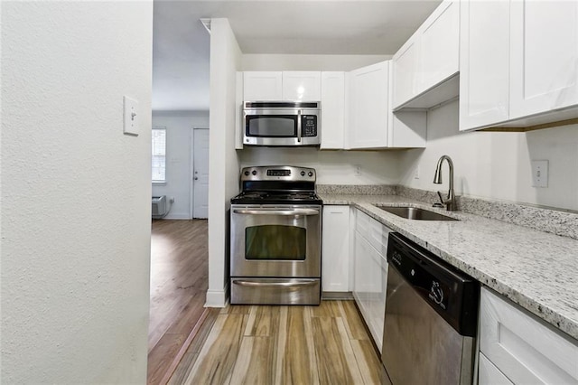 3000 July St Unit 2115, Baton Rouge, LA 70808 - kitchen with light stone counters, light wood-style flooring, appliances with stainless steel finishes, white cabinets, and a sink