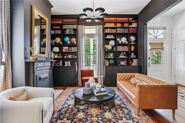 living area featuring a fireplace, wood finished floors, and a chandelier