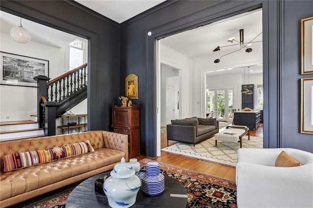 living room with stairway, wood finished floors, and ornamental molding