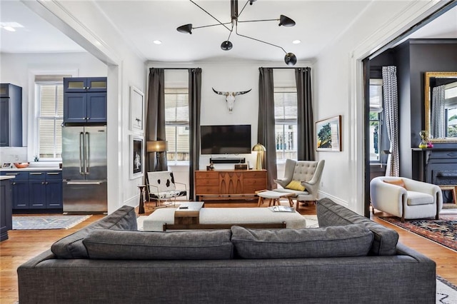 living room featuring a notable chandelier, recessed lighting, light wood-type flooring, and baseboards