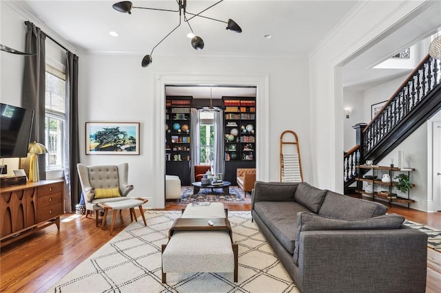 living area with recessed lighting, stairway, wood finished floors, and crown molding