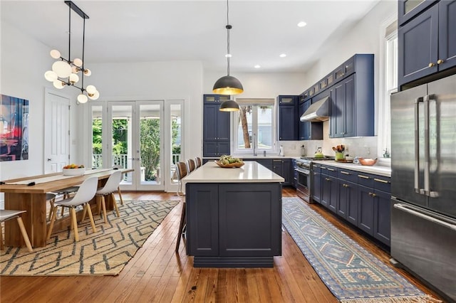 kitchen featuring ventilation hood, light countertops, recessed lighting, dark wood-style floors, and high end appliances