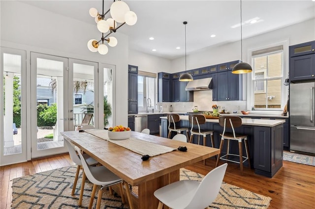 dining area featuring recessed lighting, wood-type flooring, and a chandelier