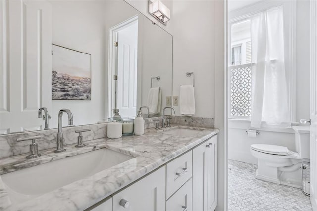 full bath featuring a sink, toilet, and double vanity