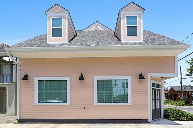 exterior space featuring roof with shingles