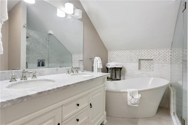 bathroom with tile patterned floors, a sink, a stall shower, and double vanity