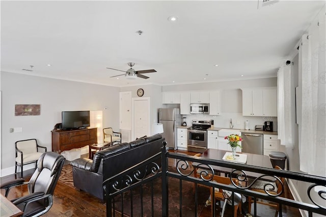 living area with baseboards, recessed lighting, dark wood-style flooring, ceiling fan, and crown molding