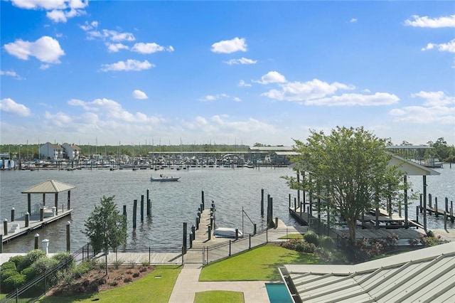 dock area with boat lift, fence, and a water view