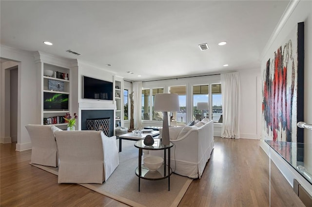 living room with visible vents, recessed lighting, a fireplace, and wood finished floors