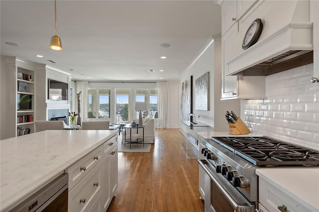 kitchen featuring light wood-style flooring, high end stainless steel range, open floor plan, white cabinets, and custom exhaust hood