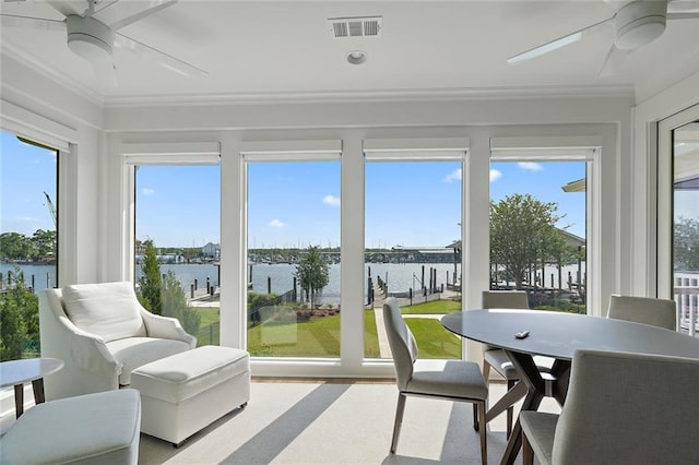 sunroom with plenty of natural light, visible vents, a water view, and ceiling fan