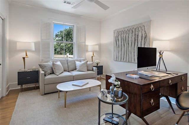 living area with light wood-style flooring, a ceiling fan, visible vents, and baseboards