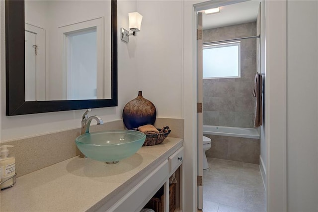 full bathroom with tile patterned flooring, toilet, vanity, and tiled shower / bath