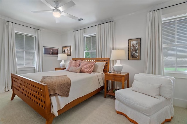 bedroom with a ceiling fan, visible vents, and light carpet