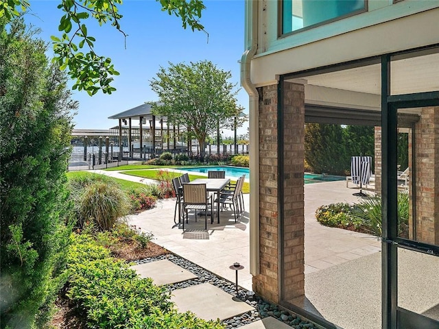 view of patio featuring an outdoor pool and fence