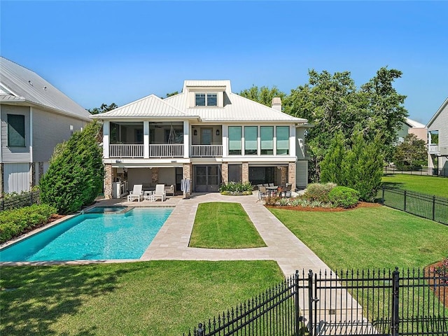 back of property featuring a yard, a sunroom, fence private yard, a patio area, and metal roof