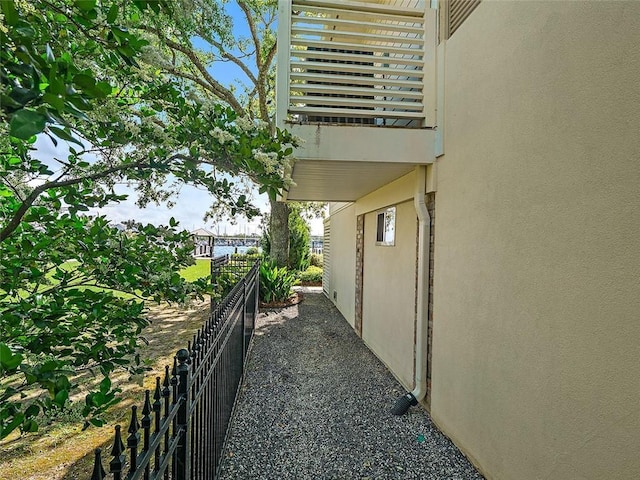 view of side of property featuring stucco siding and fence