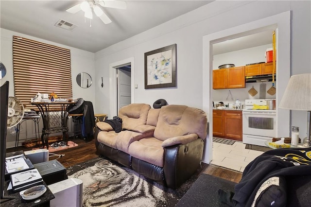 living room featuring ceiling fan, visible vents, and light wood-style floors