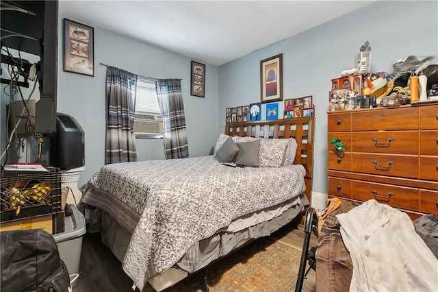 bedroom with cooling unit and wood finished floors