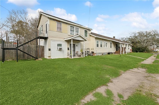 rear view of property with fence and a yard