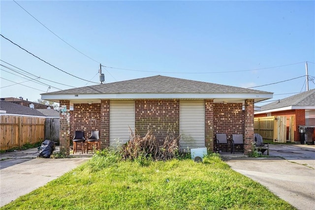 view of property exterior with a patio area, brick siding, and fence