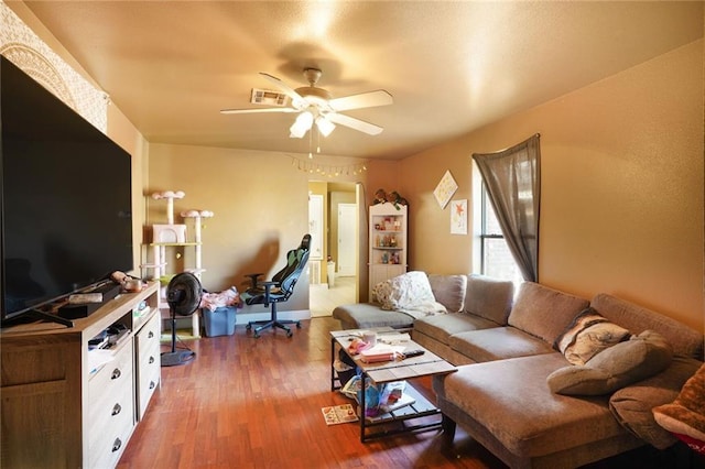 living room featuring visible vents, wood finished floors, and ceiling fan