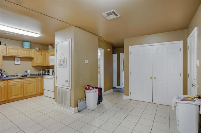 504 Dubarry Pl, Chalmette, LA 70043 - kitchen with light brown cabinetry, range, white microwave, and light tile patterned flooring