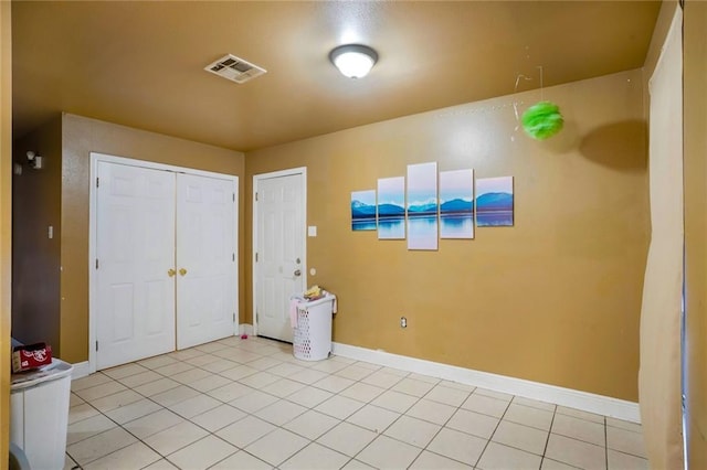 foyer entrance with light tile patterned floors, baseboards, and visible vents