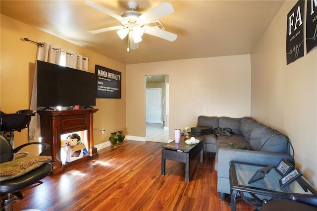 living room with a ceiling fan, wood finished floors, and baseboards