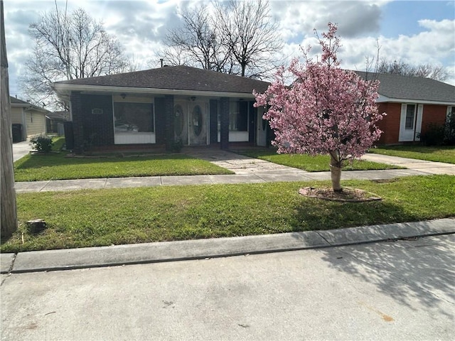 view of front facade with a front yard and brick siding