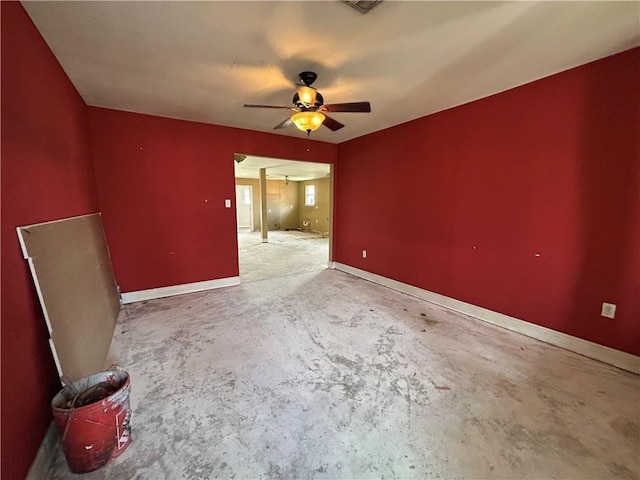 empty room with baseboards, concrete flooring, and a ceiling fan