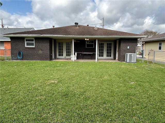 back of house featuring a fenced backyard, french doors, and a yard