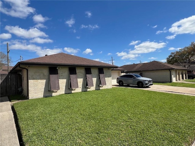 view of front facade featuring roof with shingles, an attached garage, concrete driveway, a front lawn, and brick siding