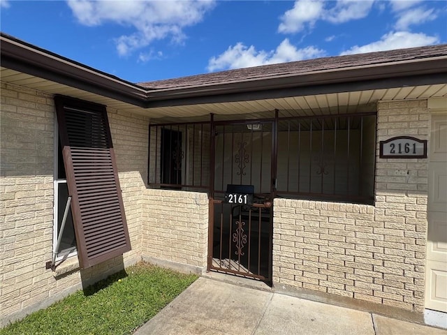 view of exterior entry featuring brick siding