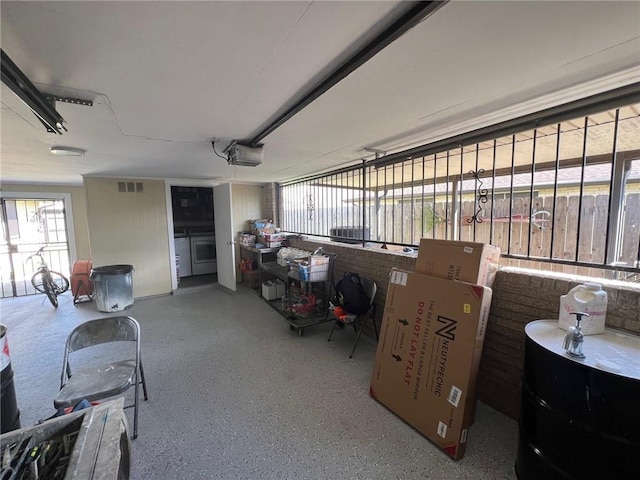 garage featuring visible vents, washer and dryer, and a garage door opener