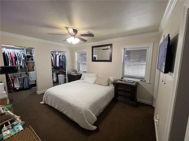 bedroom featuring multiple closets, baseboards, dark colored carpet, and ornamental molding