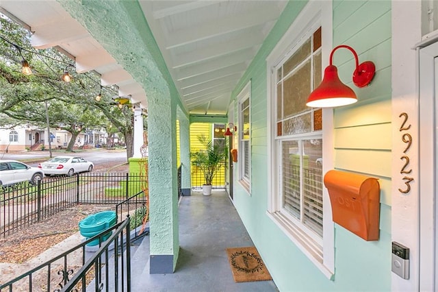 view of patio featuring covered porch and fence