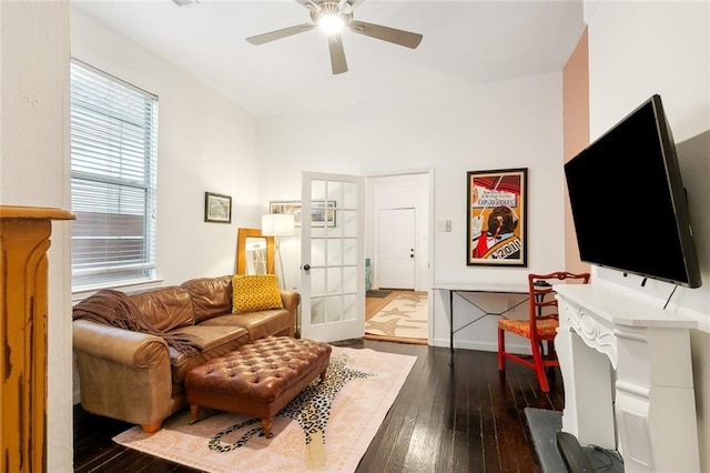 living area featuring dark wood-style floors, baseboards, and ceiling fan